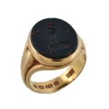 A Victorian 18 carat gold bloodstone signet ring, the oval bloodstone panel carved with a crest,