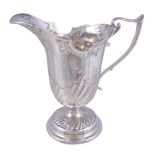 An Edwardian silver helmet shaped jug by Charles Edwards, London 1905, with an angular scroll