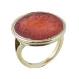 A 19th century carnelian ring, the oval carnelian panel carved with an armorial, in a collet