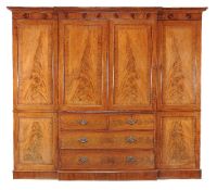 A George III mahogany breakfront clothes press, circa 1800, the moulded cornice and frieze above a