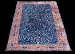 A Tabriz carpet, the navy field decorated with opposing flowering urns, the ochre border with