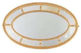 A George III oval wall mirror, circa 1800, the central plate surrounded by an divided outer plate,