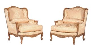 A pair of carved beech and damask upholstered wing armchairs, in Louis XV style, late 19th