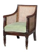 A Regency mahogany bergere armchair, circa 1815, the moulded rectangular back and downswept arms
