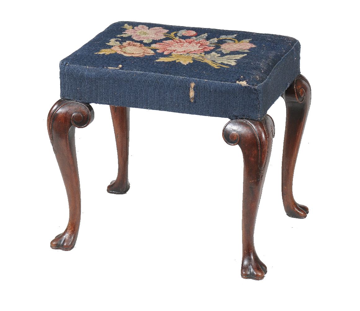 A Queen Anne walnut stool, circa 1710, the upholstered seat incorporating a floral needlework panel,