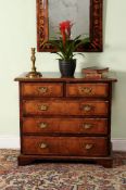 A George I walnut chest of drawers, circa 1720, the quarter veneered and crossbanded top above two