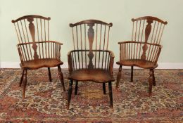 A companion set of three ash and elm Windsor armchairs, second half 18th Century, each with scrolled