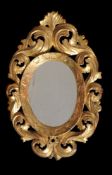 A pair of Continental carved giltwood oval wall mirrors, late 18th century, each plate within a