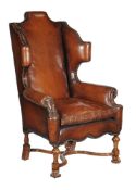 A walnut and studded leather upholstered armchair, in William & Mary style, late 19th/early 20th