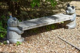 A sculpted granite garden bench, late 20th century, the rectangular seat supported by a carved model