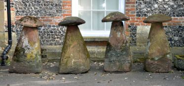 A set of four substantial rough hewn red sandstone staddle stones and caps, probably 18th century,