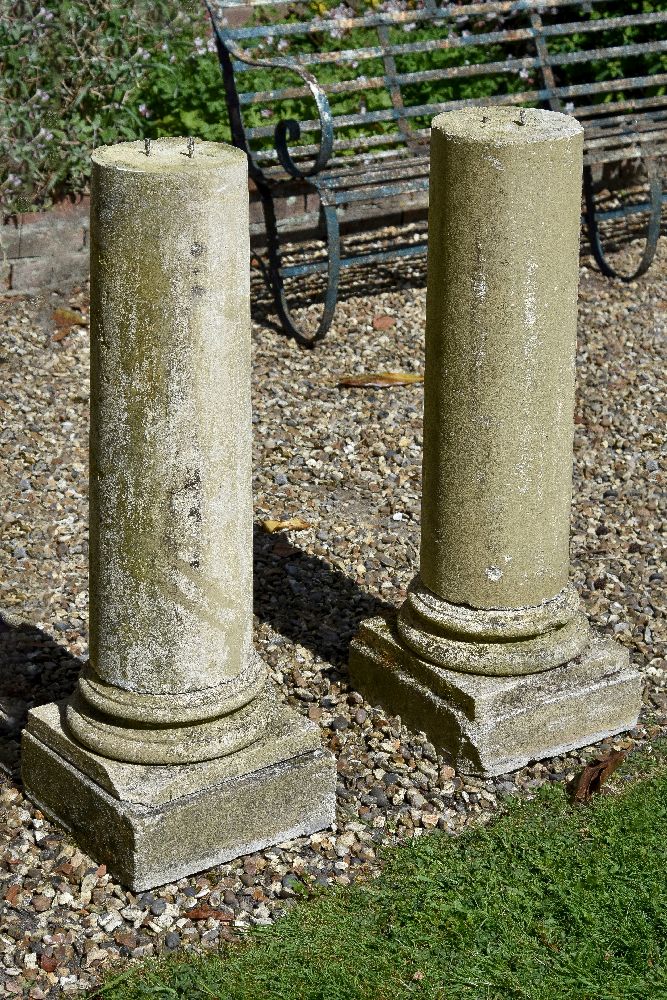 A pair of stone composition columnar pedestals, 20th century, with moulded socles and square