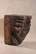 A Mediaeval sculpted oak corbel modelled with a male head, possibly a portrayal of a king,