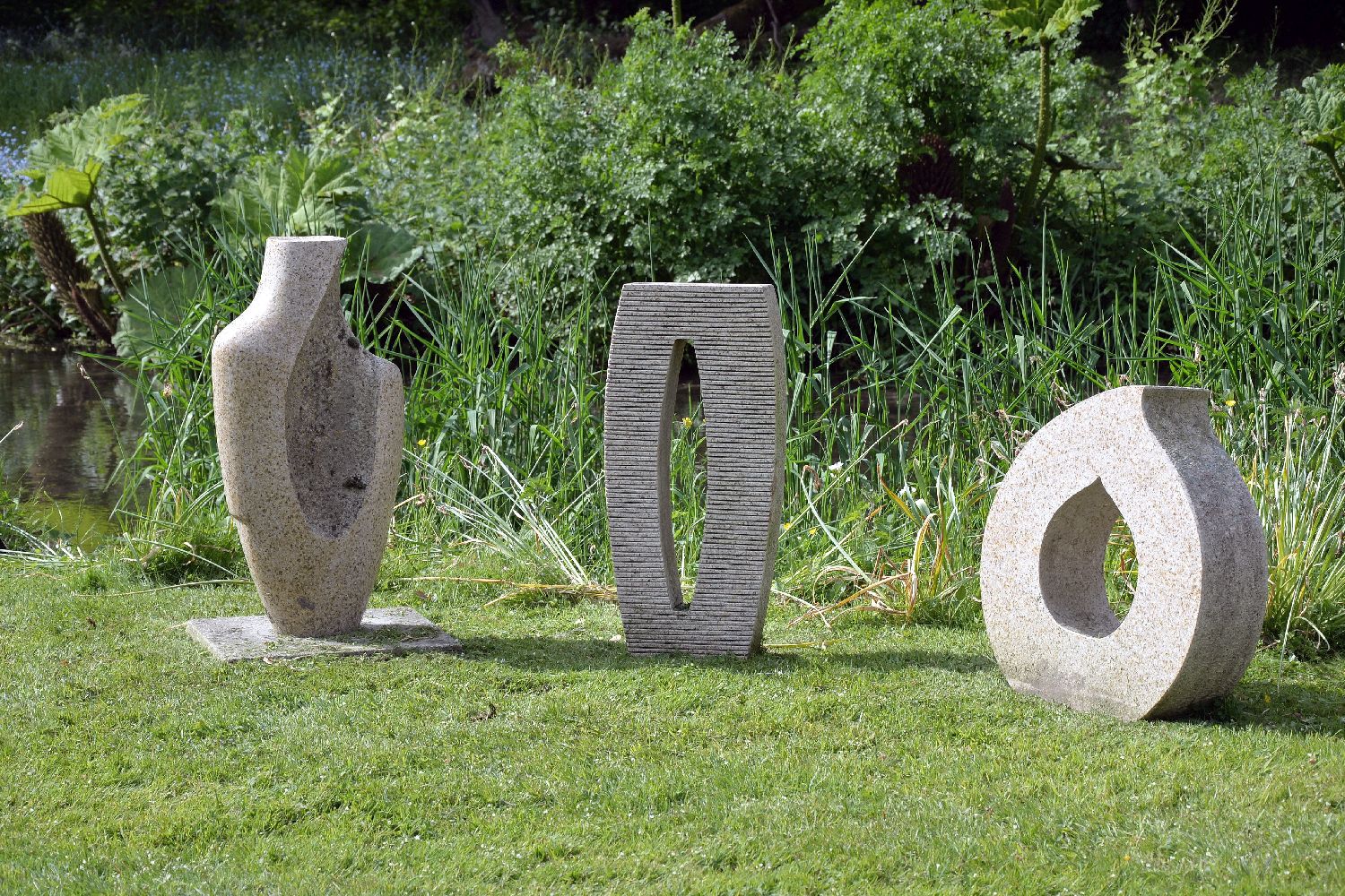 Three rough cut and polished granite abstract sculptural forms, late 20th century, one in the form