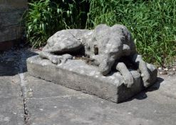 A stone composition model of a hound, early 20th century, modelled recumbent, on an integral