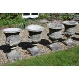 A set of four Victorian stone composition twin handled garden urns, probably by Austin & Seeley,