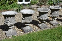 A set of four Victorian stone composition twin handled garden urns, probably by Austin & Seeley,