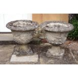 A pair of stone composition garden urns, second half 20th century, with everted rims above grapevine