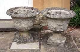 A pair of stone composition garden urns, second half 20th century, with everted rims above grapevine