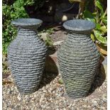 A pair of polished and rough hewn granite urns, late 20th century, 61cm high; and a stone