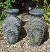 A pair of polished and rough hewn granite urns, late 20th century, 61cm high; and a stone