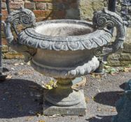 A stone composition twin handled garden urn, second half 20th century, the foliate cast mounts