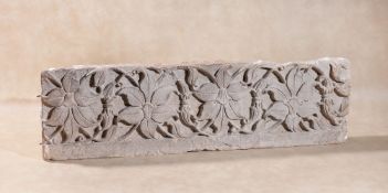 A French relief sculpted limestone frieze panel, early 16th century, carved with four blooms