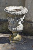 A pair of stone composition garden urns, 20th century, each with foliate cast everted rim, grapevine