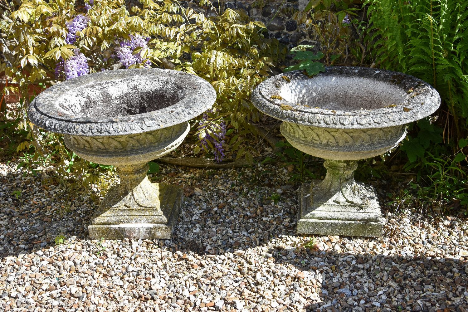 A pair of stone composition garden urns, second half 20th century, with everted rims above lattice