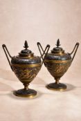 A pair of Continental parcel gilt and patinated bronze twin handled urns and covers in