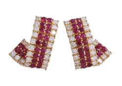 A pair of ruby and diamond earrings, the twisted panels set with a double row of circular cut