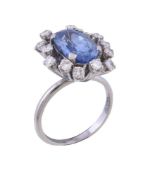 A sapphire and diamond cluster dress ring, the oval cut sapphire weighing 4.48 carats within a