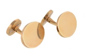 A pair of gold coloured cufflinks by Cartier, the polished oval terminals with swivel bar