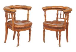 A pair of Victorian walnut and leather upholstered library armchairs, circa 1870, each with one