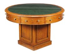 A Victorian oak drum library table, circa 1880, the circular top above four drawers and four