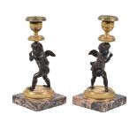 A pair of Charles X or Louis Philippe patinated and gilt bronze figural candlesticks, circa 1830,