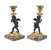 A pair of Charles X or Louis Philippe patinated and gilt bronze figural candlesticks, circa 1830,