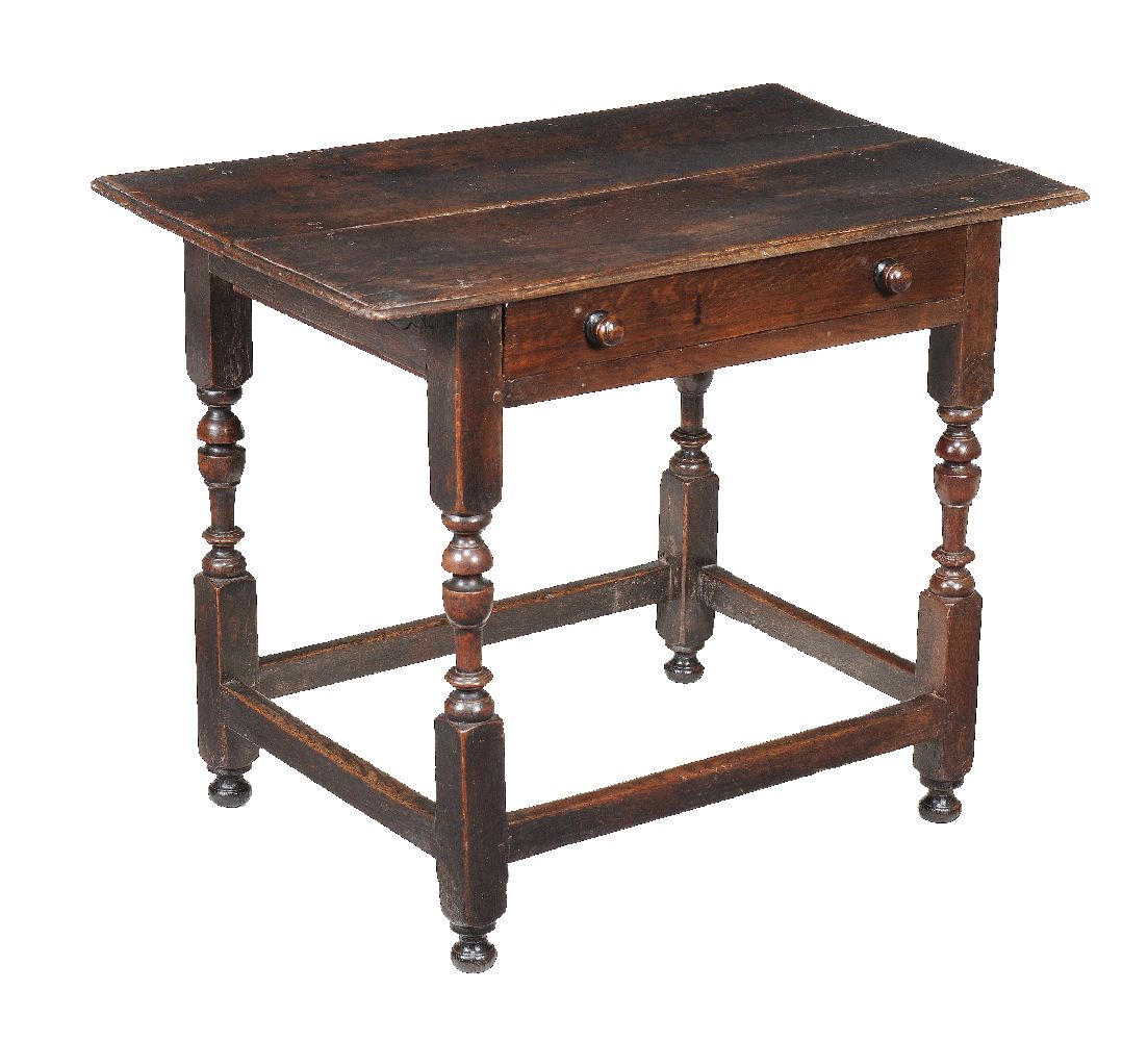 An oak side table, first half 18th century, the plank top above a frieze drawer and turned