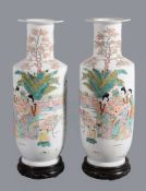 A pair of Chinese Rose-Verte rouleau vases, 20th century, painted with ladies and children on a