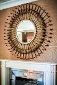 A gilt metal wall mirror in the form of a stylised flowerhead, of recent manufacture, the circular