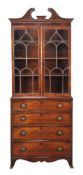 A George III mahogany bookcase, circa 1800, the astragal bookcase above a chest of four drawers,