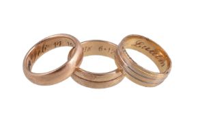 A gold coloured band ring, the shank inscribed Feb 14 1918, 7g; together with a further band ring