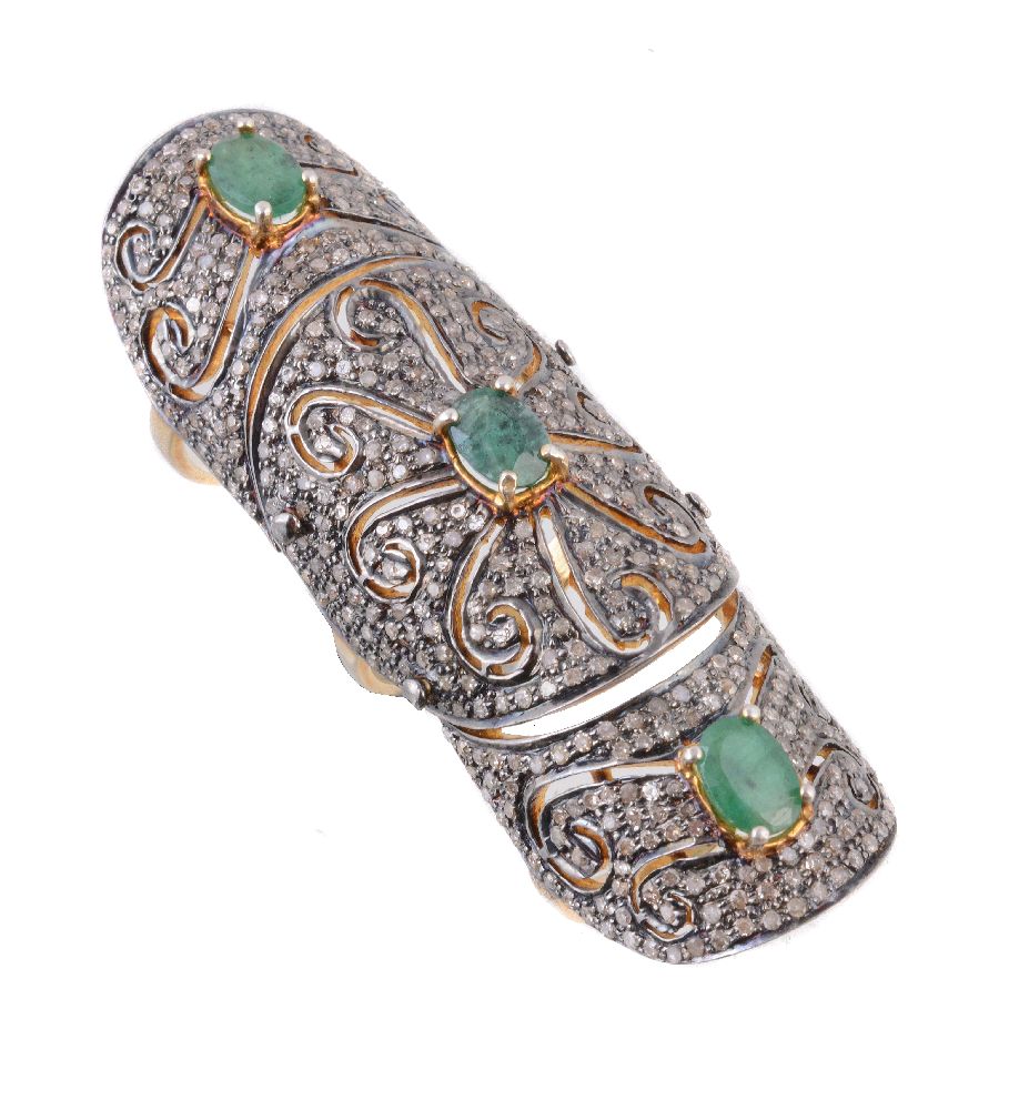 A diamond and emerald articulated dress ring, the pierced panels pavé set with diamond points, and