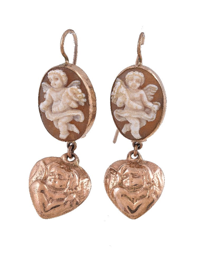 A pair of cameo earrings, the oval shell panel carved with a cherub, suspending a heart shaped