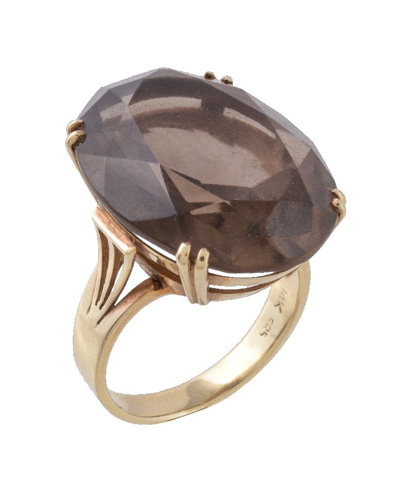 A 1970s smoky quartz dress ring, the oval cut smoky quartz in a claw setting, stamped 14k, finger