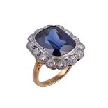 A synthetic sapphire and diamond ring, the cushion cut synthetic sapphire collet set within a