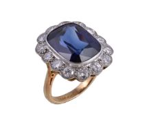A synthetic sapphire and diamond ring, the cushion cut synthetic sapphire collet set within a
