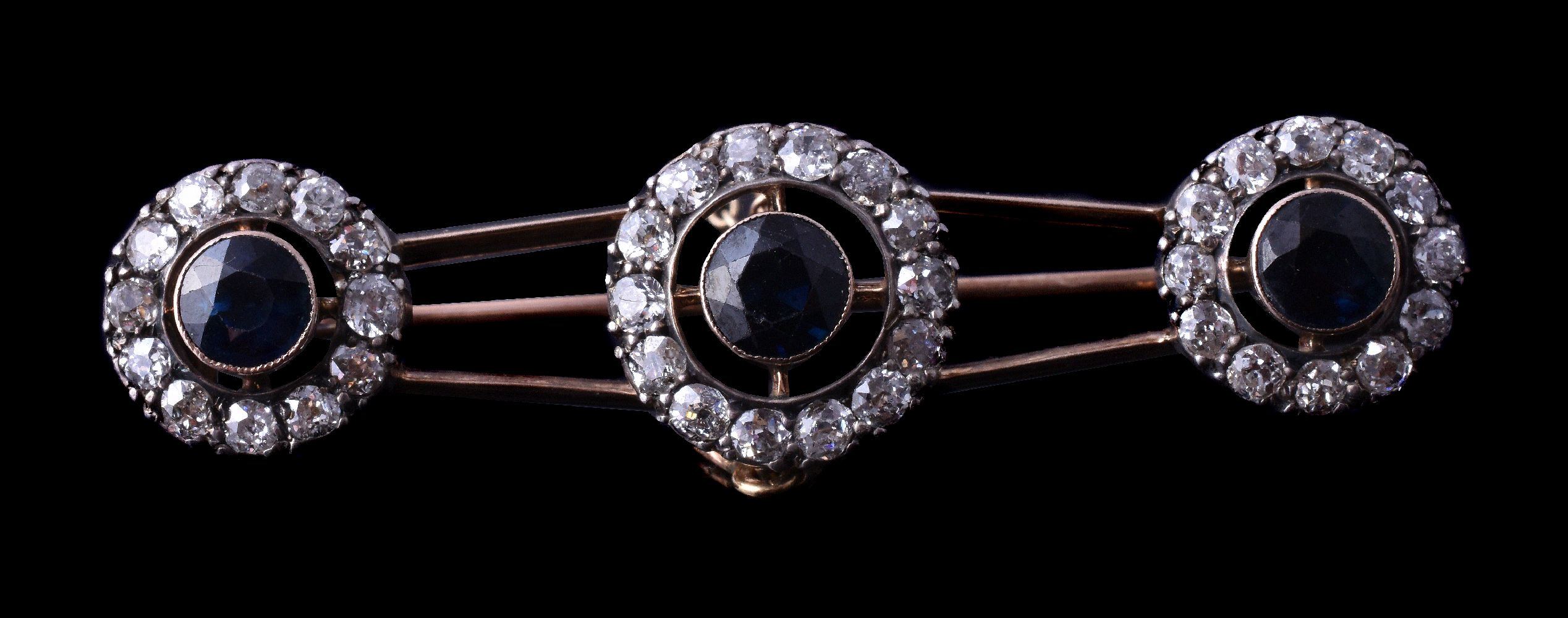 An early 20th century sapphire and diamond brooch, circa 1900, the three clusters each set with a