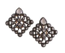 A pair of diamond ear clips, the openwork gold backed silver panels set with rose cut diamonds, with