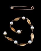 A gold coloured cultured pearl bracelet, the cultured pearls with fancy links in between, with a